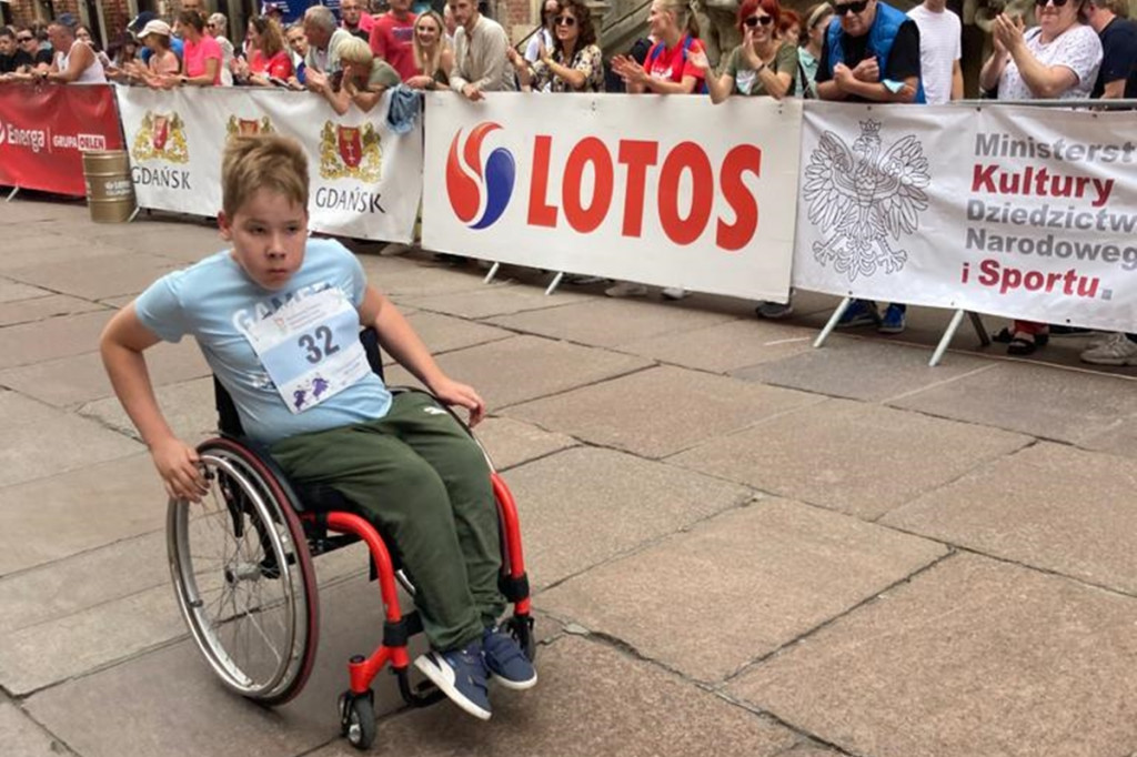 Adaś z Kiełpina podczas wyścigu na wózkach inwalidzkich