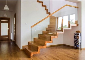Drewniane schody ładnie łączą drewniany taras z wnętrzem, tu schody z Artcorestudio